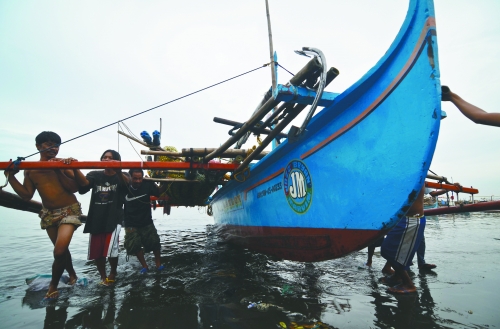 當(dāng)?shù)貢r間8月10日，馬尼拉海域，漏油事故附近居民開始清理海灘上的油污